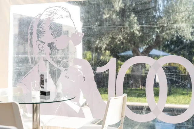 Decoración de la fiesta: un gran «100» y la silueta de Mémé con gafas de sol, en blanco y negro