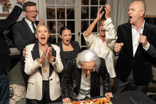 La familia y los invitados, de blanco y negro, aplauden a Mémé al celebrar sus 100 años