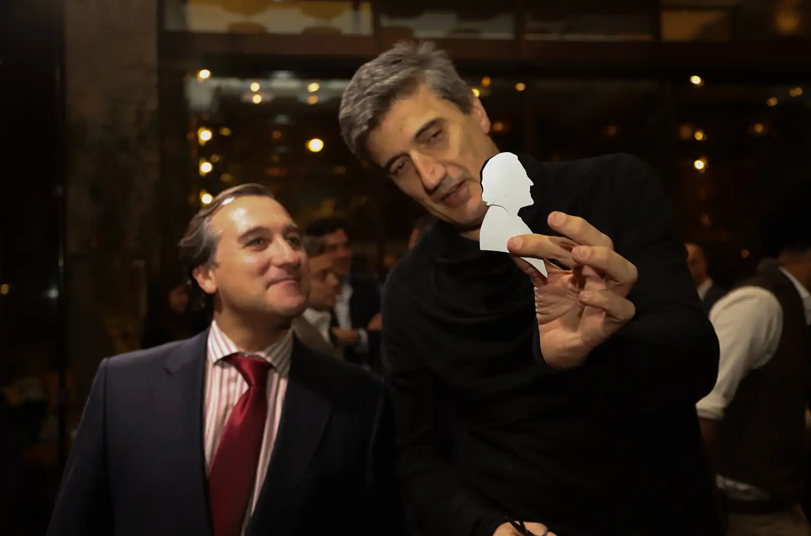 Igor Kucinic mostrando a un invitado el retrato de silueta terminado
