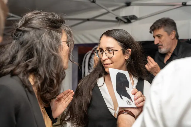 Unas invitadas descubren y comparan sus retratos de silueta recortados durante la fiesta